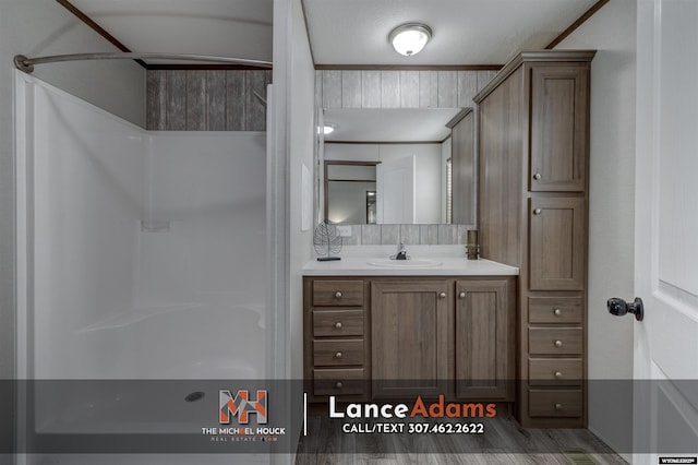bathroom with vanity, wood-type flooring, and a shower