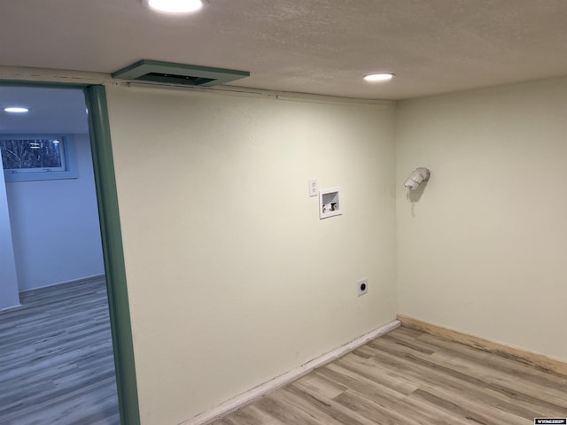 laundry area featuring hookup for a washing machine, a textured ceiling, and light wood-type flooring