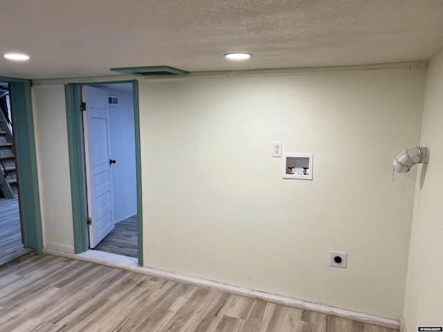 laundry room with washer hookup, hookup for an electric dryer, a textured ceiling, and light wood-type flooring