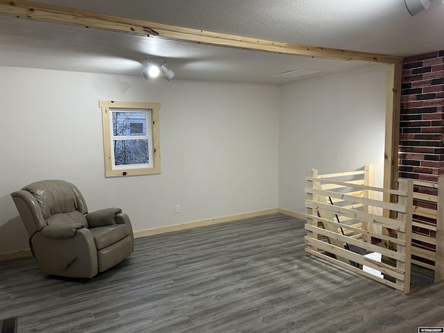 sitting room featuring dark hardwood / wood-style floors and a textured ceiling