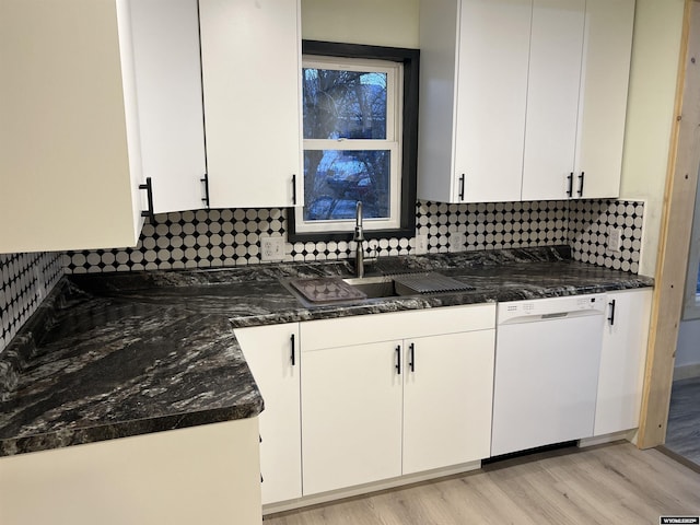 kitchen featuring white dishwasher, sink, and white cabinets