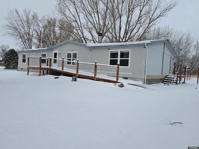 snow covered house featuring a deck