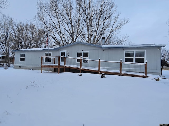 snow covered house featuring a wooden deck