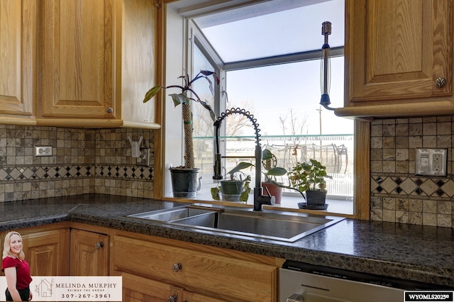 kitchen with dark countertops, brown cabinetry, and stainless steel dishwasher