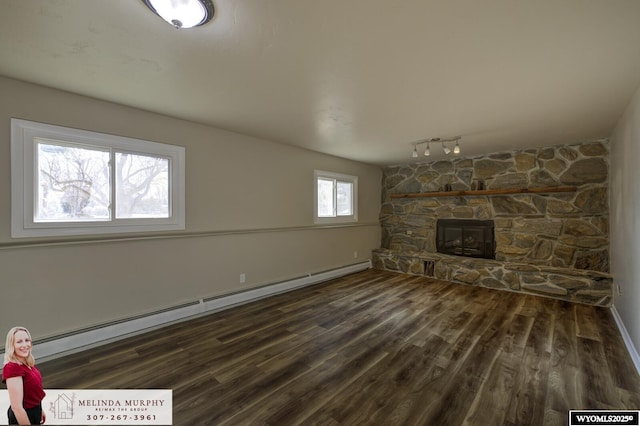 unfurnished living room featuring dark wood finished floors, a fireplace, and baseboard heating