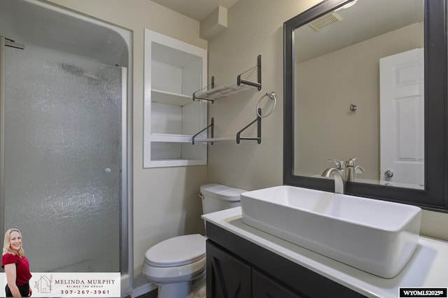 bathroom with toilet, an enclosed shower, vanity, and visible vents