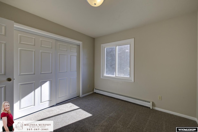 unfurnished bedroom with dark colored carpet, a closet, a baseboard radiator, and baseboards