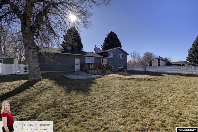 exterior space with a patio area, fence, a deck, and a lawn