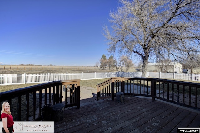 deck featuring a rural view and a fenced backyard