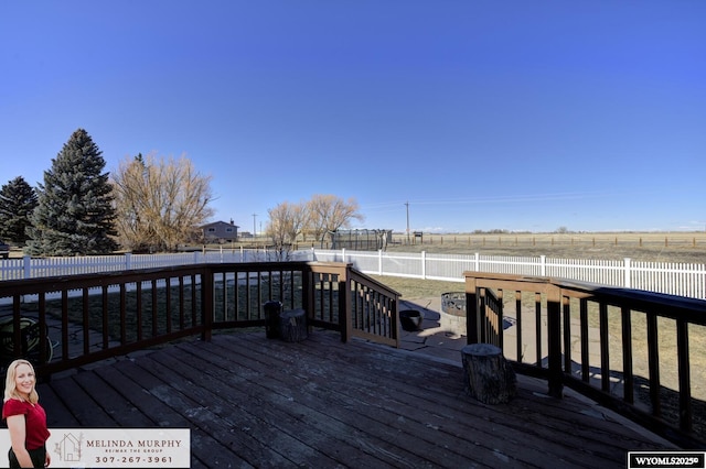 wooden terrace with a fenced backyard