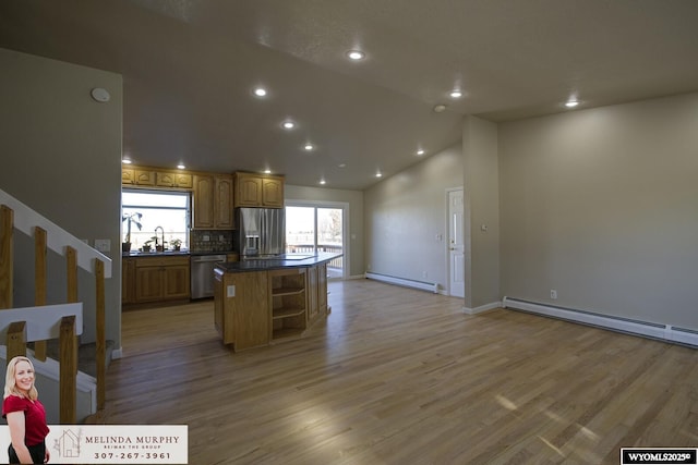 kitchen featuring dark countertops, a kitchen island, appliances with stainless steel finishes, a baseboard heating unit, and open shelves