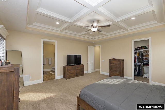 bedroom featuring coffered ceiling, a spacious closet, crown molding, and carpet