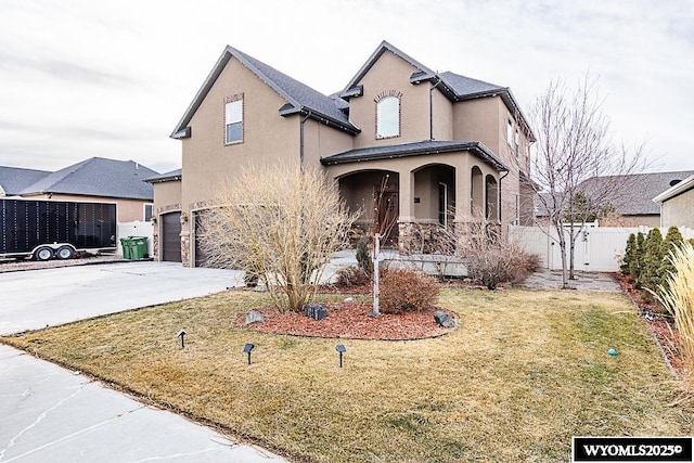 view of property featuring a garage, a front yard, and a porch