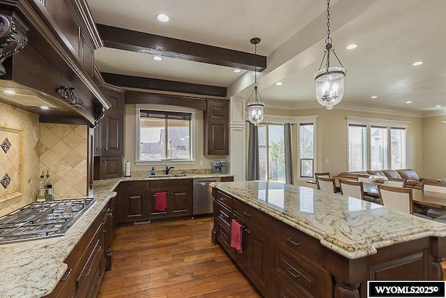 kitchen with sink, hanging light fixtures, dark hardwood / wood-style floors, a kitchen island, and stainless steel appliances