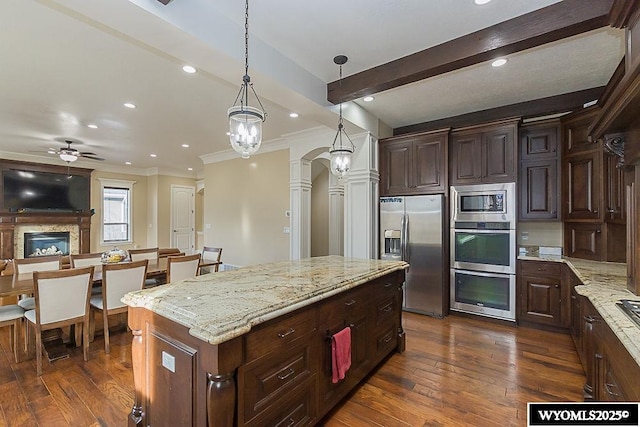 kitchen featuring a kitchen island, dark hardwood / wood-style floors, decorative light fixtures, light stone counters, and stainless steel appliances