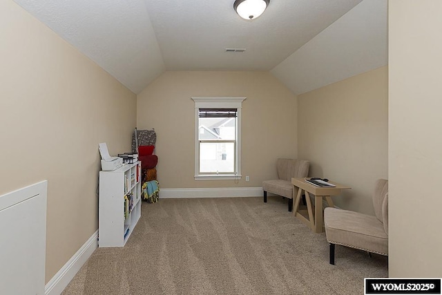 living area with lofted ceiling and light colored carpet