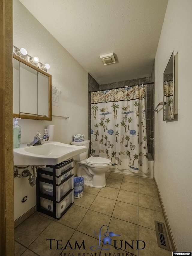 full bathroom with shower / bathtub combination with curtain, sink, tile patterned flooring, a textured ceiling, and toilet