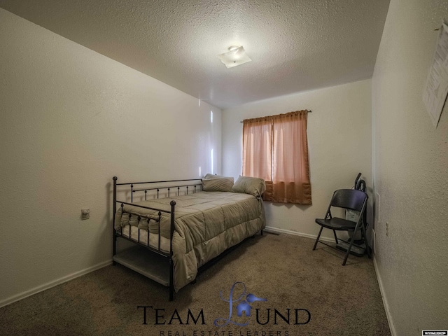 bedroom featuring a textured ceiling and carpet flooring