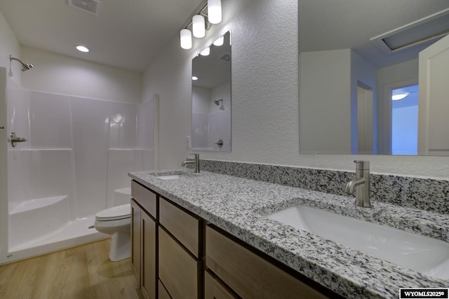 bathroom with toilet, wood-type flooring, vanity, and walk in shower