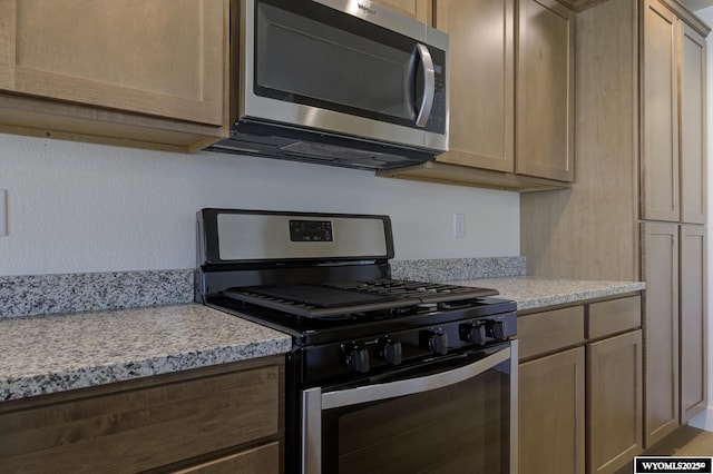 kitchen featuring light brown cabinetry and appliances with stainless steel finishes