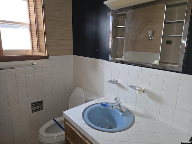 bathroom featuring vanity, tile walls, and toilet