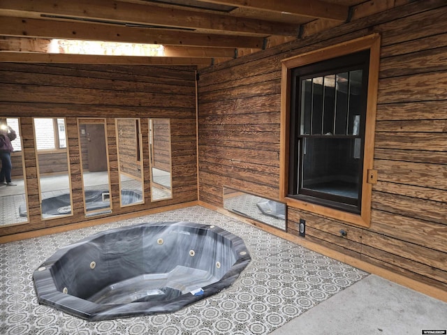 interior space with beamed ceiling and a jacuzzi