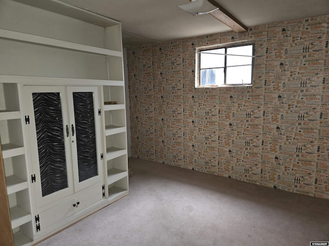 unfurnished room featuring brick wall, light colored carpet, and french doors