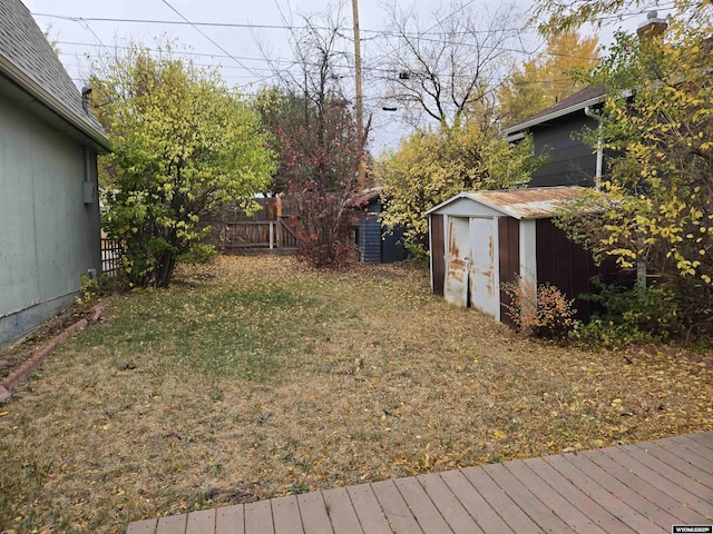 view of yard featuring a wooden deck and a storage shed