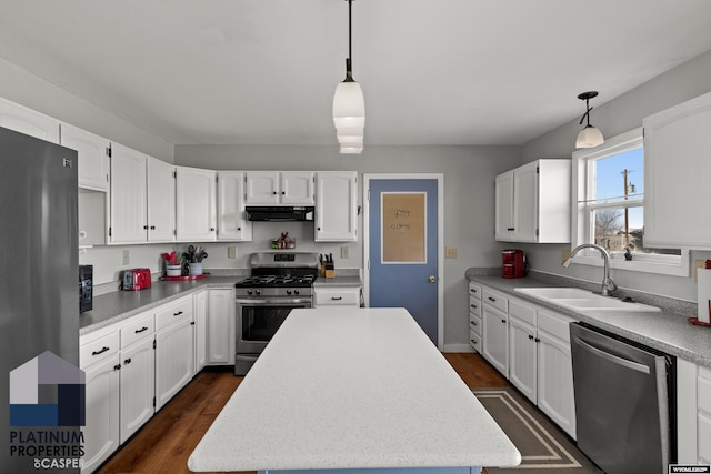 kitchen featuring pendant lighting, stainless steel appliances, sink, and a kitchen island