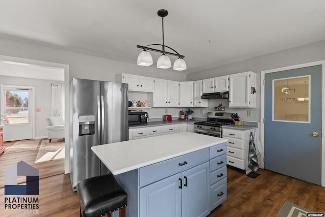 kitchen featuring white cabinetry, decorative light fixtures, a center island, dark hardwood / wood-style floors, and stainless steel appliances