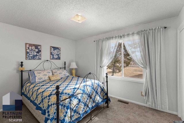 carpeted bedroom featuring a textured ceiling