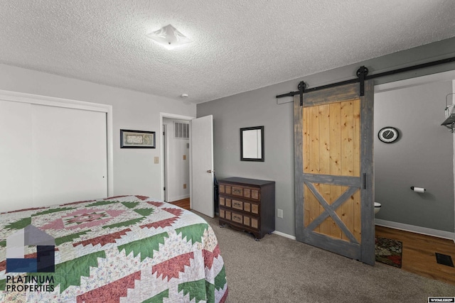 bedroom featuring a barn door, a textured ceiling, and a closet