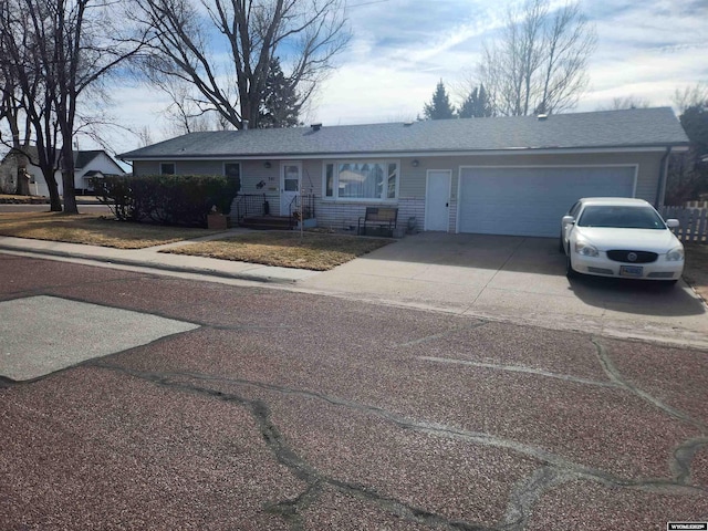 ranch-style home with an attached garage, driveway, and a shingled roof