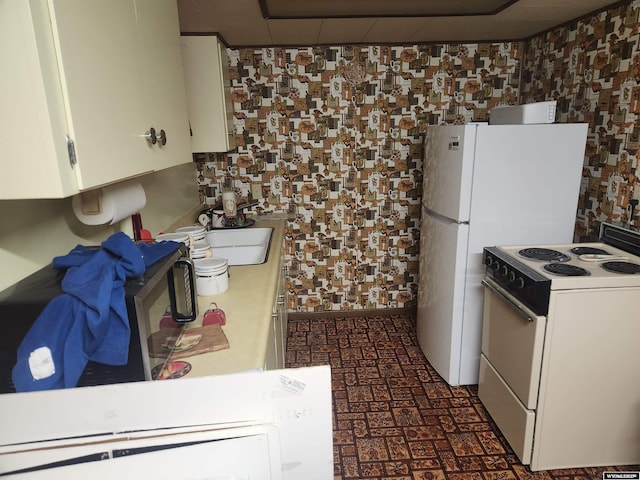 kitchen featuring light countertops, white cabinets, white electric stove, and a sink