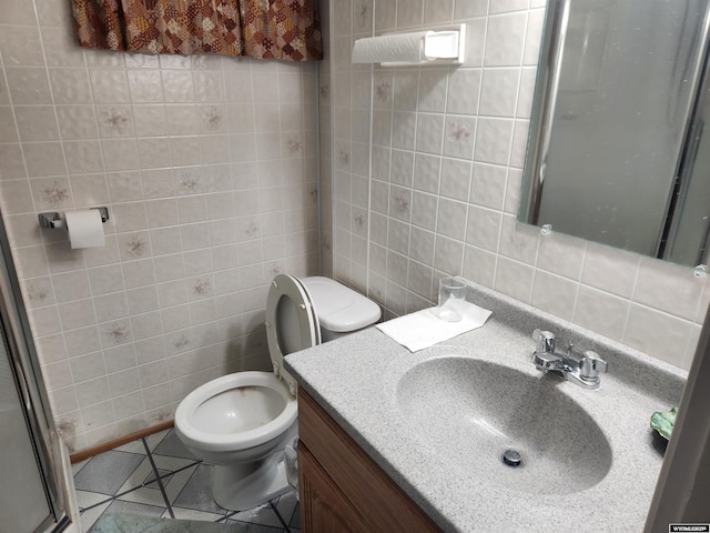 full bathroom featuring toilet, a shower with door, tile patterned flooring, vanity, and tile walls