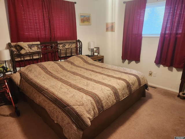 carpeted bedroom with visible vents and baseboards