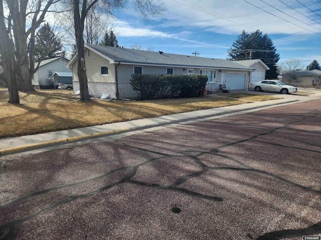 single story home with a garage, driveway, and a front yard