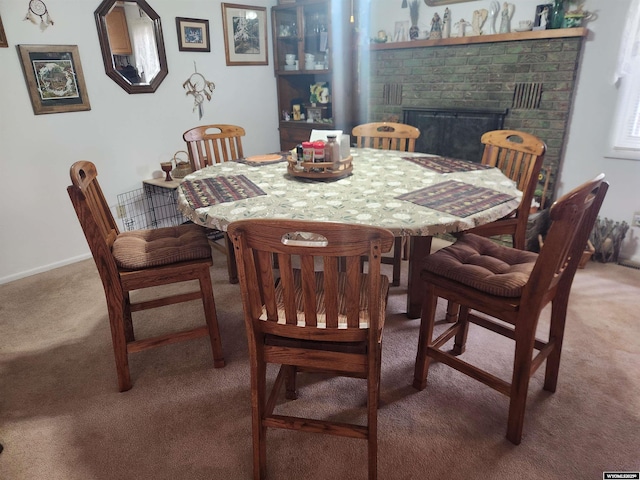 carpeted dining space featuring a fireplace and baseboards