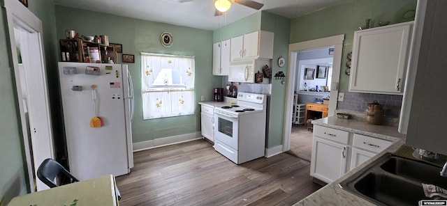 kitchen with white cabinetry, sink, and white appliances