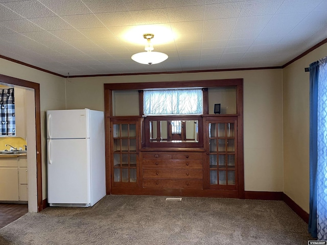 interior space with crown molding, carpet, and sink