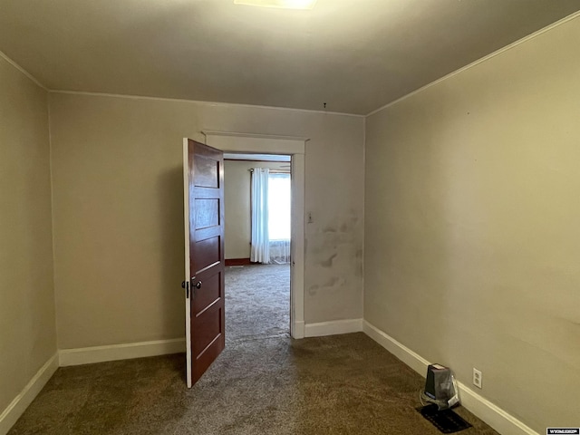 spare room with dark colored carpet