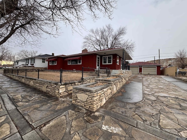 view of front of property featuring a garage and an outdoor structure