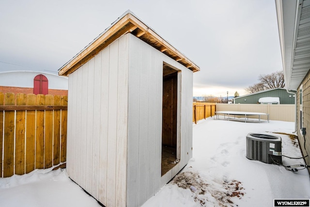 snow covered structure featuring a trampoline and central air condition unit