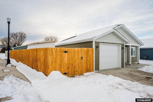 view of snow covered exterior featuring a garage