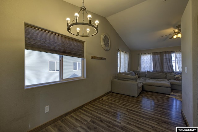 unfurnished living room featuring dark wood-type flooring, ceiling fan with notable chandelier, and vaulted ceiling