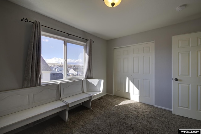 unfurnished bedroom with a closet and dark colored carpet