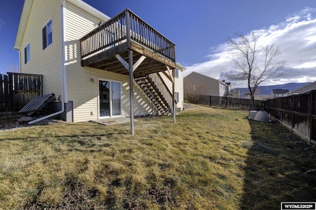 rear view of property featuring a wooden deck and a yard