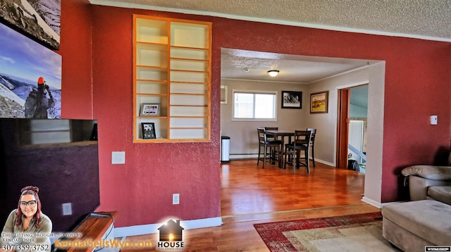 living room featuring hardwood / wood-style flooring, crown molding, a textured ceiling, and a baseboard heating unit