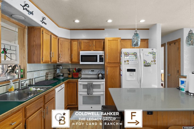 kitchen with white appliances, decorative light fixtures, sink, and a textured ceiling