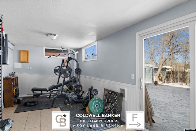 workout room with light tile patterned flooring and a textured ceiling